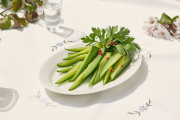 Lightly salted cucumbers, bright daylight, overhead presentation on white plate