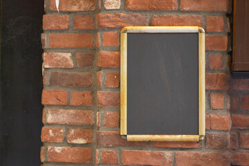 Vintage chalkboard mounted on a rustic brick wall