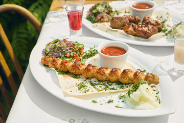 Chicken lula kebab and pork shashlik platter, bright natural lighting, overhead composition