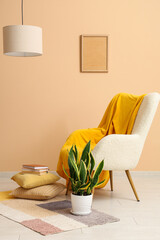 Armchair with plaid, plant and pillows with books in living room