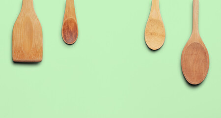 Wooden Kitchen Utensils Arranged on a Pale Green Background. File with Clipping Path.