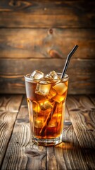 Refreshing iced tea in a glass with ice and straw on a wooden table