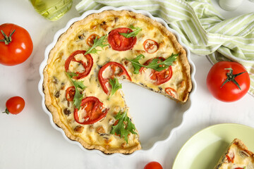 Cut delicious tomato tart with arugula leaves on white background