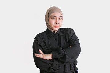 Confident Muslim woman wearing beige hijab and black shirt posing with a gentle smile on white...
