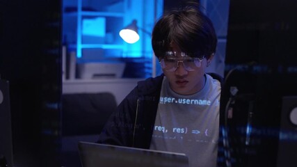 Focused Asian young programmer coding complex software late night home office blue light environment - Powered by Adobe