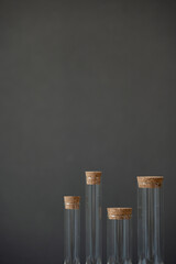 Glass test tubes with cork stoppers on dark background