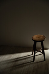 Wooden stool in dramatic light and shadow