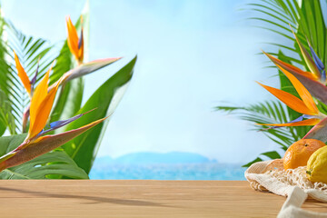 An exotic tropical setup with fruit and bird-of-paradise flowers beside soft beach sand. There's a...