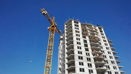 Construction site with crane and building against a clear blue sky, showcasing progress in modern architecture, urban development, highlighting the hustle, bustle of urban construction environments.