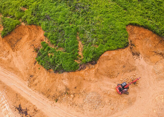 A tractor is mining rocks and sand as seen from the air, around an agricultural area, in a rural area in East Kutai Regency, East Kalimantan, Indonesia.
