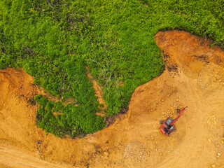 A tractor is mining rocks and sand as seen from the air, around an agricultural area, in a rural area in East Kutai Regency, East Kalimantan, Indonesia.