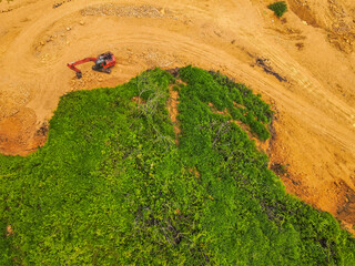 A tractor is mining rocks and sand as seen from the air, around an agricultural area, in a rural area in East Kutai Regency, East Kalimantan, Indonesia.