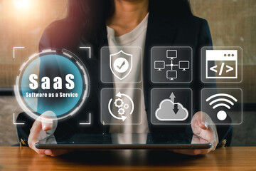 Businesswoman showcasing SaaS icons on a tablet, symbolizing cloud technology and modern software...