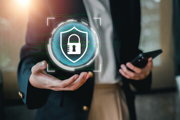 A business professional holds a digital shield icon, symbolizing cybersecurity and data protection...