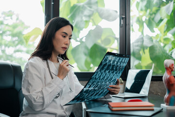 Female doctor examines X-ray in a modern office, surrounded by medical tools and natural light.