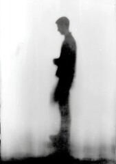 Silhouetted figure, blurred, against a hazy white background