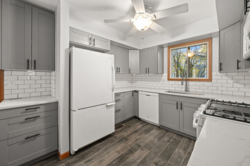 Wide View of Modern Kitchen with large window in front of kitchen sink, Bright Design