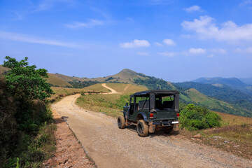 Off road sport utility vehicle on the scenic mountain road in Coorg district , Karnataka, India.