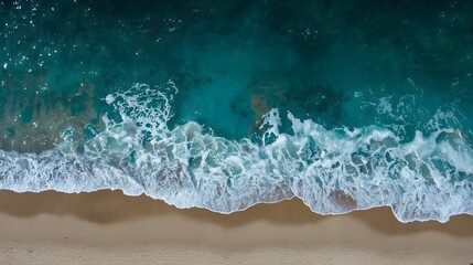 Aerial view of turquoise ocean waves gently crashing on a sandy beach, capturing the beauty of nature with clear water textures for summer, travel, relaxation, and background designs

