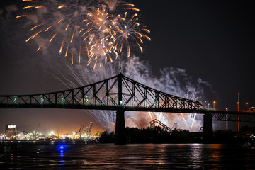 Drone flight through holiday fireworks above water with reflection on the black sky background