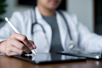 Close-up of doctor using digital pen on tablet for medical data input, healthcare technology concept with physician in white coat and stethoscope, modern hospital electronic health record system.