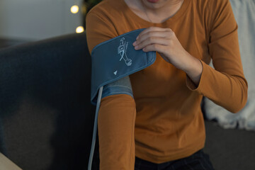 Health Monitoring. Individual using a blood pressure monitor at home.