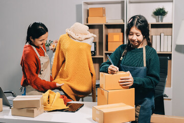 Portrait of Starting small businesses SME owners, two Asian woman check online orders Selling...