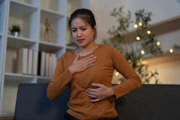 Health Awareness: Young woman experiencing abdominal pain while seated