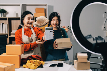 Portrait of Starting small businesses SME owners, two Asian woman check online orders Selling...