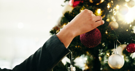 Christmas tree, decoration and hand of person in home for celebration or December holidays. Bauble,...