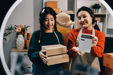 Portrait of Starting small businesses SME owners, two Asian woman check online orders Selling...