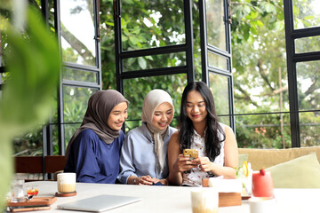 Cheerful and Pretty Asian Female Friends are Enjoying Eating food, Drinking, and Hanging Out at a...