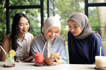 Group of Cheerful and Pretty Asian Female Friends are Enjoying a Coffeeshop While Travelling