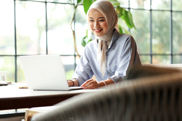 Young Asian Muslim Business Woman Wearing Hijab Working  with Laptop