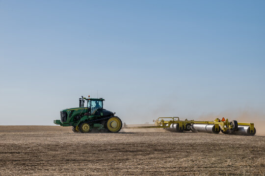 Webb, Saskatchewan- April 25, 2025:  Young farmer packing a lentil field with a roller after seeding