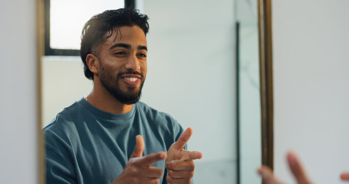 Finger guns, mirror and man in bathroom with confidence for skincare, grooming and health in home. Happy, reflection and person with shooting gesture for hygiene, wellness and morning routine