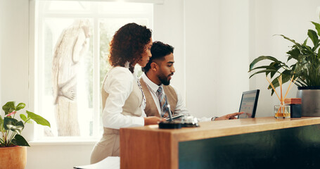 Hotel, receptionist and colleagues with computer, research and collaboration for reservation on...
