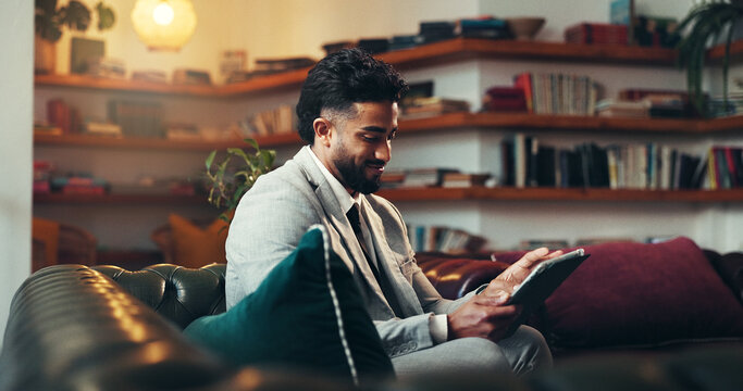 Break, night and tablet with business man on sofa in lounge of office for planning or research. App, evening and relax with corporate employee in workplace lobby for reading or report deadline - Powered by Adobe