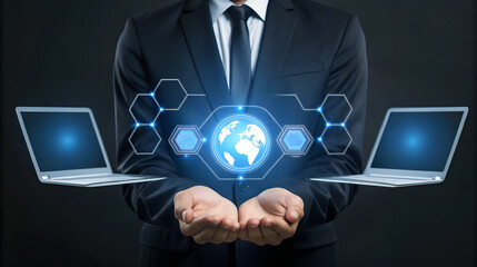Businessman holding a digital network interface with a globe and laptops