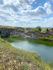Fototapeta premium Unsurpassed view from above of a steppe lake created by nature in an abandoned stone quarry under the rays of the hot summer sun.