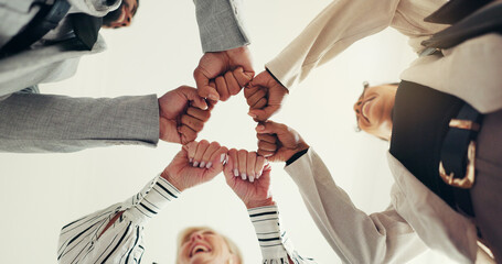Fist bump, low angle and business people at hands with team motivation, support and circle at...