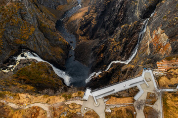 Majestic Voringsfossen waterfall with powerful cascades converging into pool within rugged gorge....
