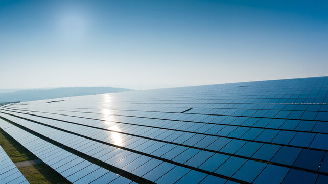 A high-angle photograph of a large solar panel array with photovoltaic cells.