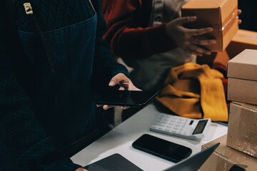 Portrait of Starting small businesses SME owners, two Asian woman check online orders Selling products working with boxs freelance work at home office, sme business online small medium enterprise