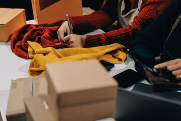 Portrait of Starting small businesses SME owners, two Asian woman check online orders Selling...