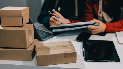 Portrait of Starting small businesses SME owners, two Asian woman check online orders Selling...