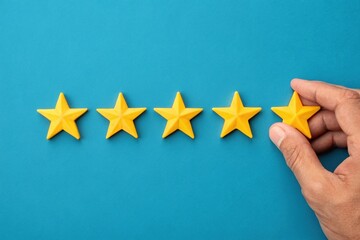 Evaluating Excellence A Hand Placing a Star to Rate Service Quality and Provide Feedback on a Blue Background