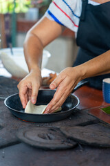 Costa Rican woman cooking handmade tortilla on wood stove