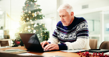Christmas, office and mature businessman on laptop for finance report, proposal and check profit...