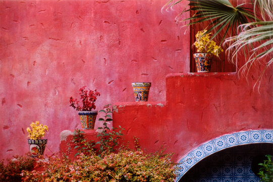 picture of the red facade and the decorative flower pots on the stairs
